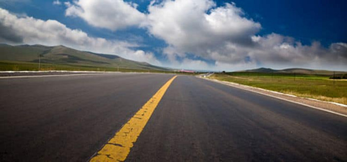La strada verso la consapevolezza La strada verso la consapevolezza-strada con linea gialla di mezzeria che finisce all’orizzonte in luogo naturale con cielo nuvoloso vista da una ripresa rasoterra