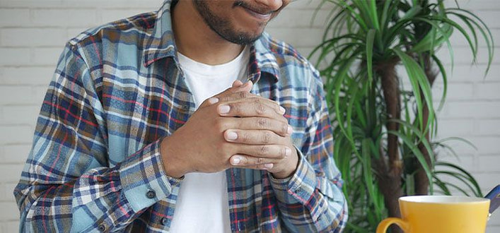 Tremori interni ansia Tremori interni ansia-ragazzo con camicia stringe le mani davanti al petto