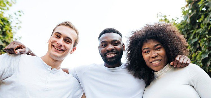 Definizione di rispetto-amici interculturali che sorridono abbracciati guardando verso l'obiettivo Definizione di rispetto-amici interculturali che sorridono abbracciati guardando verso l'obiettivo