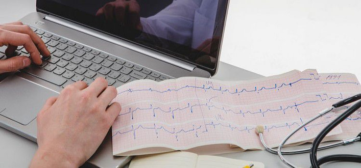 Tachicardia da ansia cause-mani di un medico al pc con da parte eletrocardiogramma e stetoscopio Tachicardia da ansia cause-mani di un medico al pc con da parte elettrocardiogramma e stetoscopio