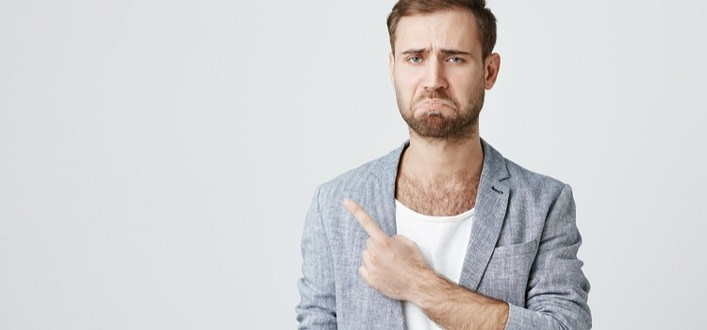 delusione significato-uomo imbronciato con dito indica qualcosa alla sua destra delusione significato-uomo imbronciato con dito indica qualcosa alla sua destra