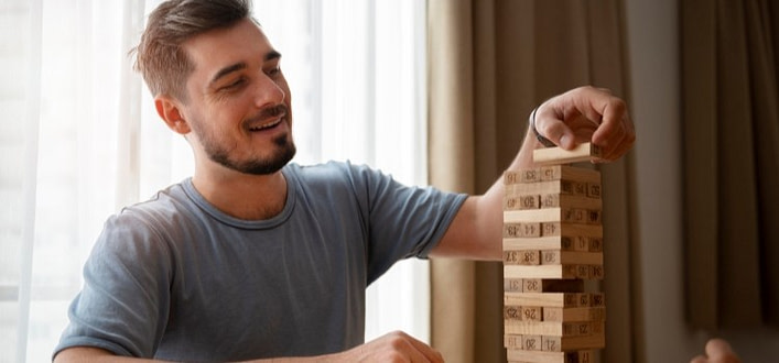 ragazzo si diverte giocando a montare in equilibrio mattoncini in legno ragazzo si diverte giocando a montare in equilibrio mattoncini in legno