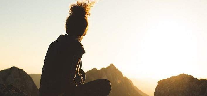 sentirsi soli dentro-ragazza su una roccia guarda il cielo al tramonto sentirsi soli dentro-ragazza su una roccia guarda il cielo al tramonto