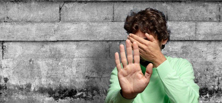 Ossessione-ragazzo copre il viso con mano e mette l'altra davanti come per fermare la telecamera Ossessione-ragazzo copre il viso con mano e mette l'altra davanti come per fermare la telecamera