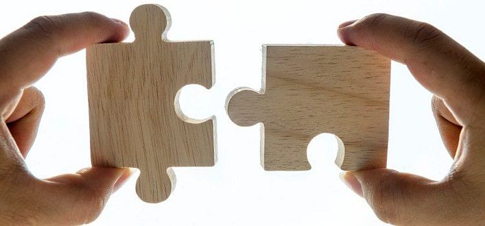 Ossessioni-mani che uniscono due pezzi complementari di puzzle in legno Ossessioni-mani che uniscono due pezzi complementari di puzzle in legno