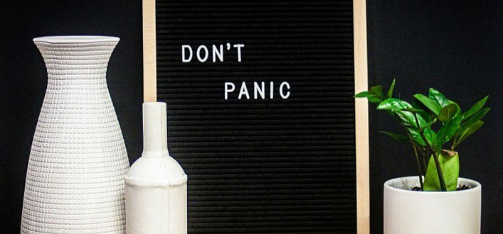 Come calmare gli attacchi di panico - lavagna con scritta don’t panic tra vasi bianchi posti ai lati Come calmare gli attacchi di panico - lavagna con scritta don’t panic tra vasi bianchi posti ai lati