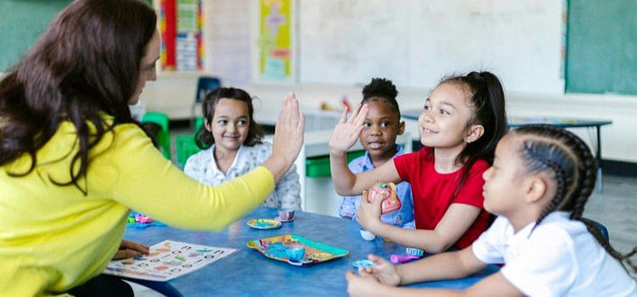 Effetto pigmalione-maestra gioca con bambini che partecipano contenti Effetto pigmalione-maestra gioca con bambini che partecipano contenti