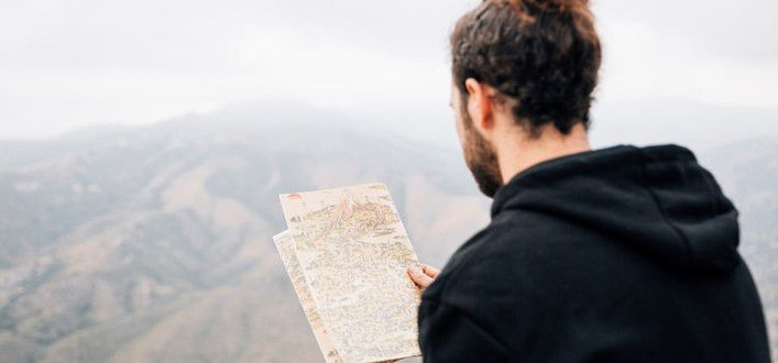 Ritrovare se stessi psicologia-primo piano di un viandante di spalle che legge la mappa Ritrovare se stessi psicologia-primo piano di un viandante di spalle che legge la mappa