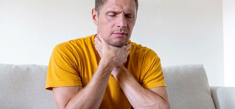 Nodo alla gola ansia - uomo che si tiene la gola con entrambe le mani