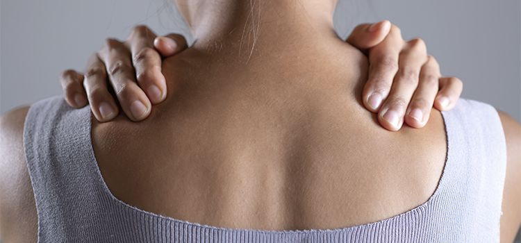 Tensione muscolare da ansia-ragazza girata di schiena che si tiene le spalle dolenti