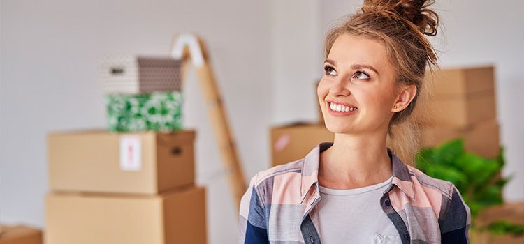 andare a vivere da soli - ragazza sorridente in una nuova casa