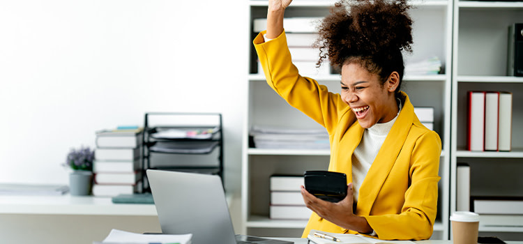 Realizzarsi-nel-lavoro-ragazza-gioisce-seduta-alla-scrivania