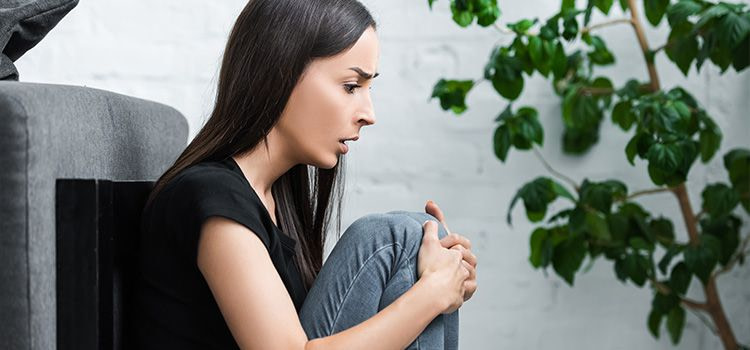 Sintomi attacchi di panico - Ragazza in ansia si tiene le ginocchia