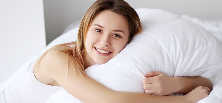 Come far passare l'ansia da soli - Ragazza sorridente che abbraccia un cuscino