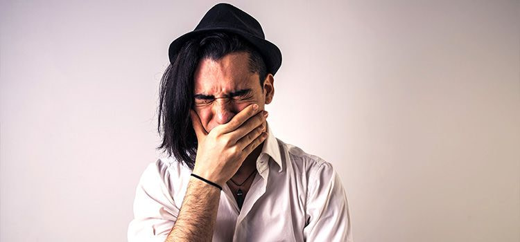 Significato di emozione - Uomo commosso si copre la bocca con la mano