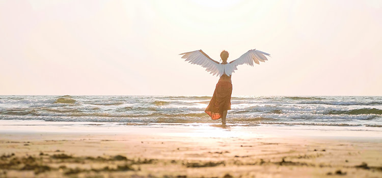 libertà di scelta - Immagine di una donna con anili d'angelo sulle spalle, davanti al mare