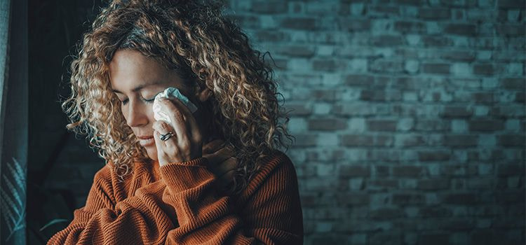 persona sensibile - donna che asciuga con un fazzoletto le lacrime