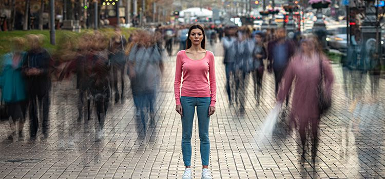 crisi esistenziali - Donna a figura intera con persone che le passano accanto sfuocate