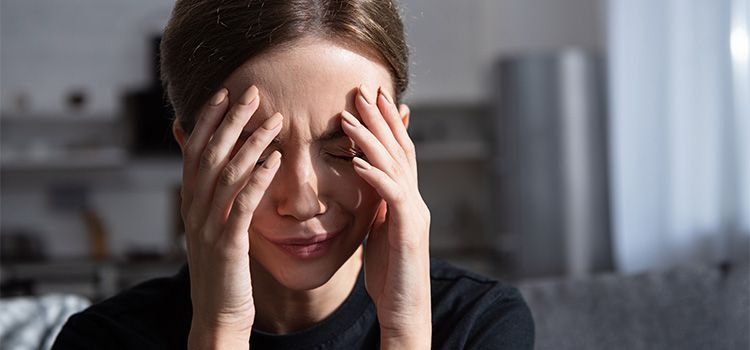 ansia senza motivo - Una ragazza con le mani sul viso in segno di malessere