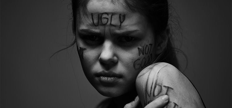 brutto carattere - Una ragazza in primo piano con viso crucciato e scritte offensive sulla pelle