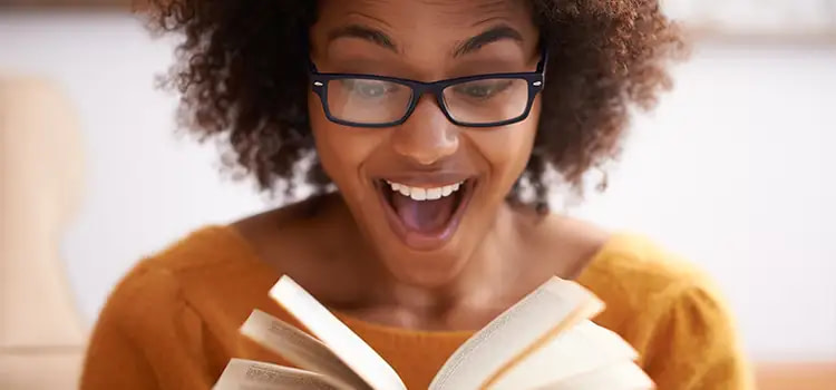 come vivere - Una donna sorridente che legge un libro